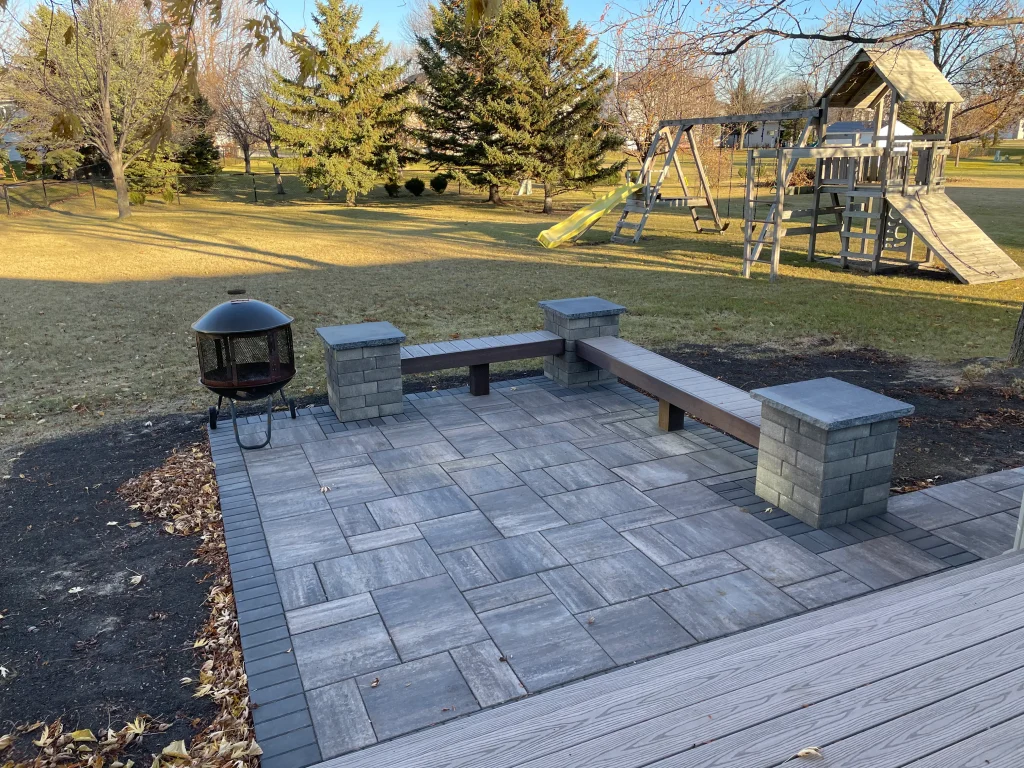 IMG_1654 Outdoor backyard stone patio with ledges and wooden seating.