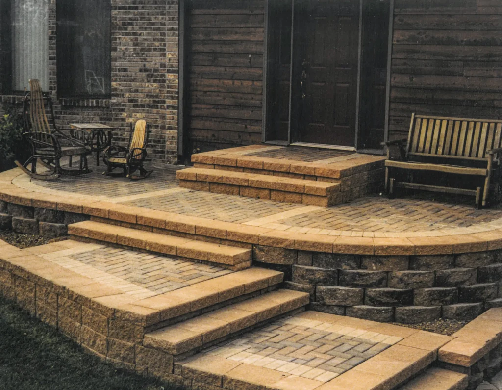 SKM_C451i24121116400 Brick patio with elevated stone steps.