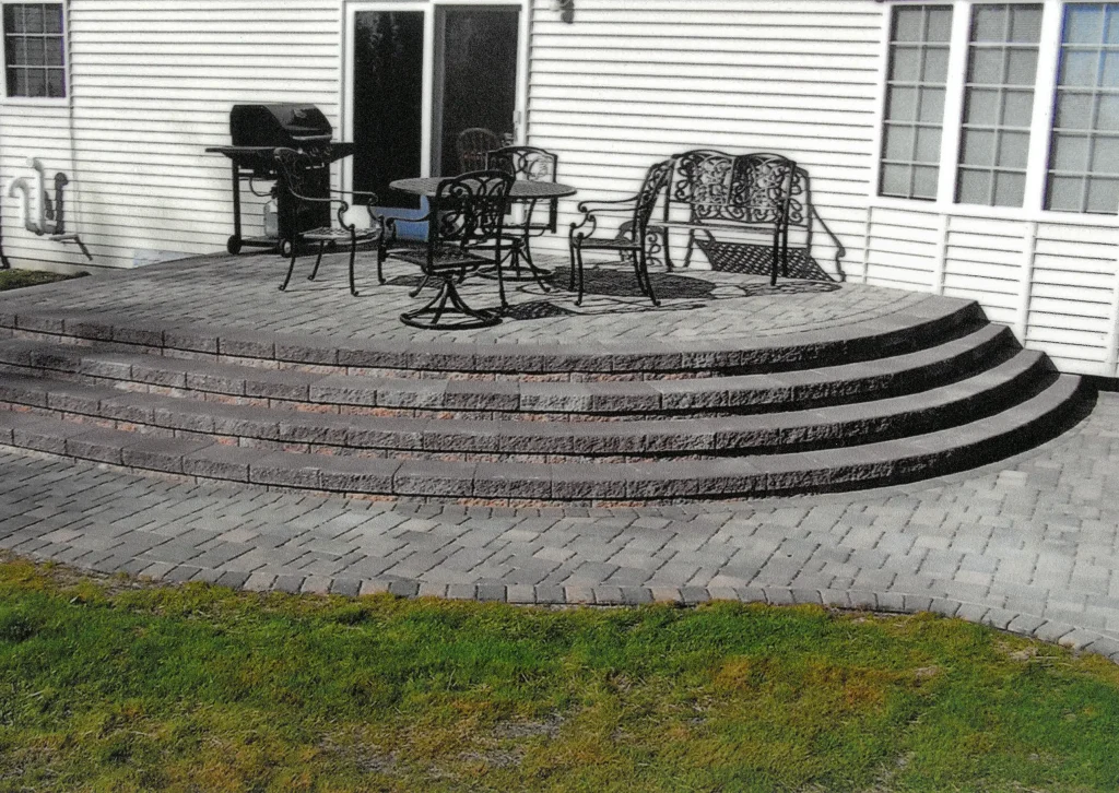 SKM_C451i24121117010 Stone patio with stairs and walkway.