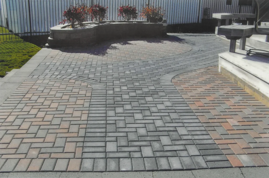 SKM_C451i24121207480 Brick outdoor patio with ledge for plants.