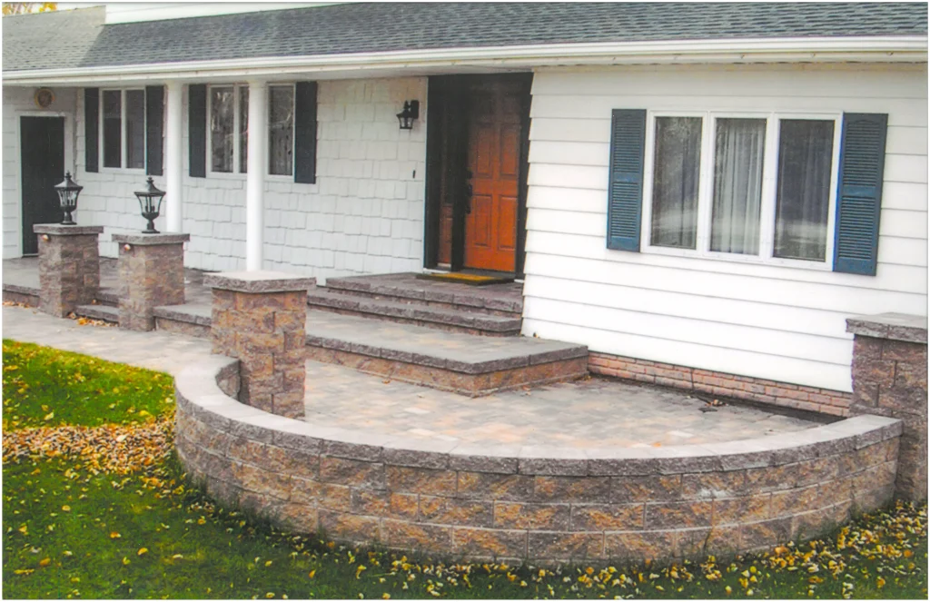 SKM_C451i24121716100_EDIT Red stone front patio with columns, stairs, and ledge.