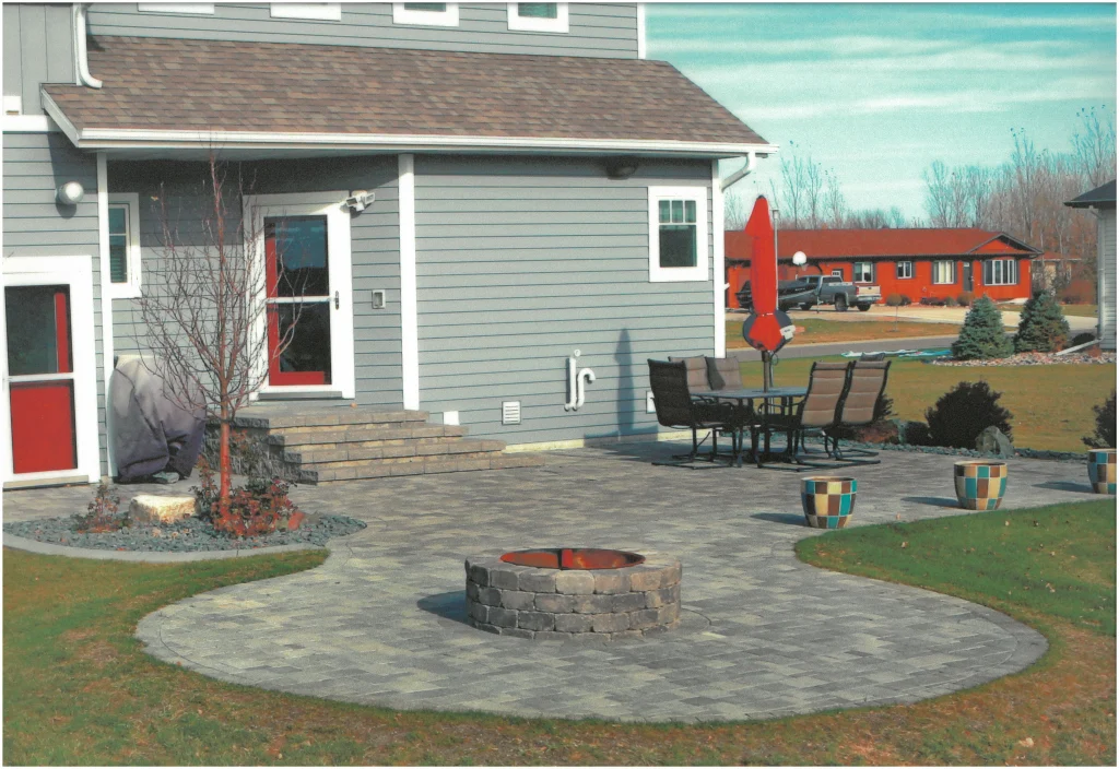 SKM_C451i24121716380 Backyard stone patio with firepit.